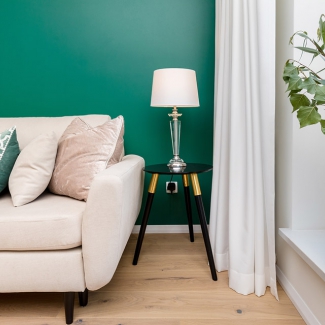 Sofa na tle butelkowo zielonej ściany